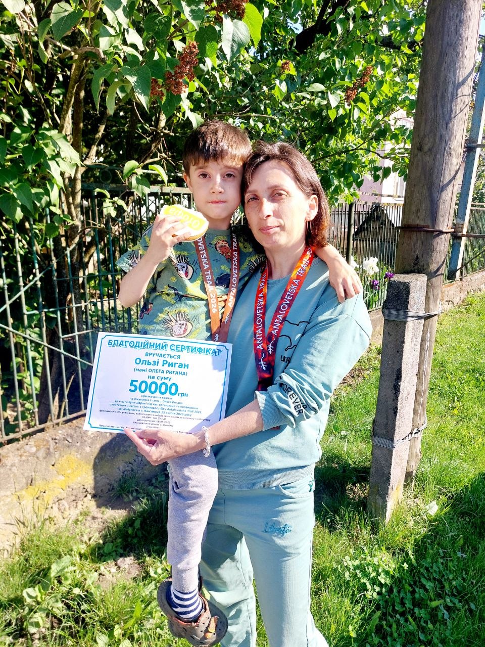Мама Олега Ригана з Олегом та благодійним сертифікатом на 50 000 гривень